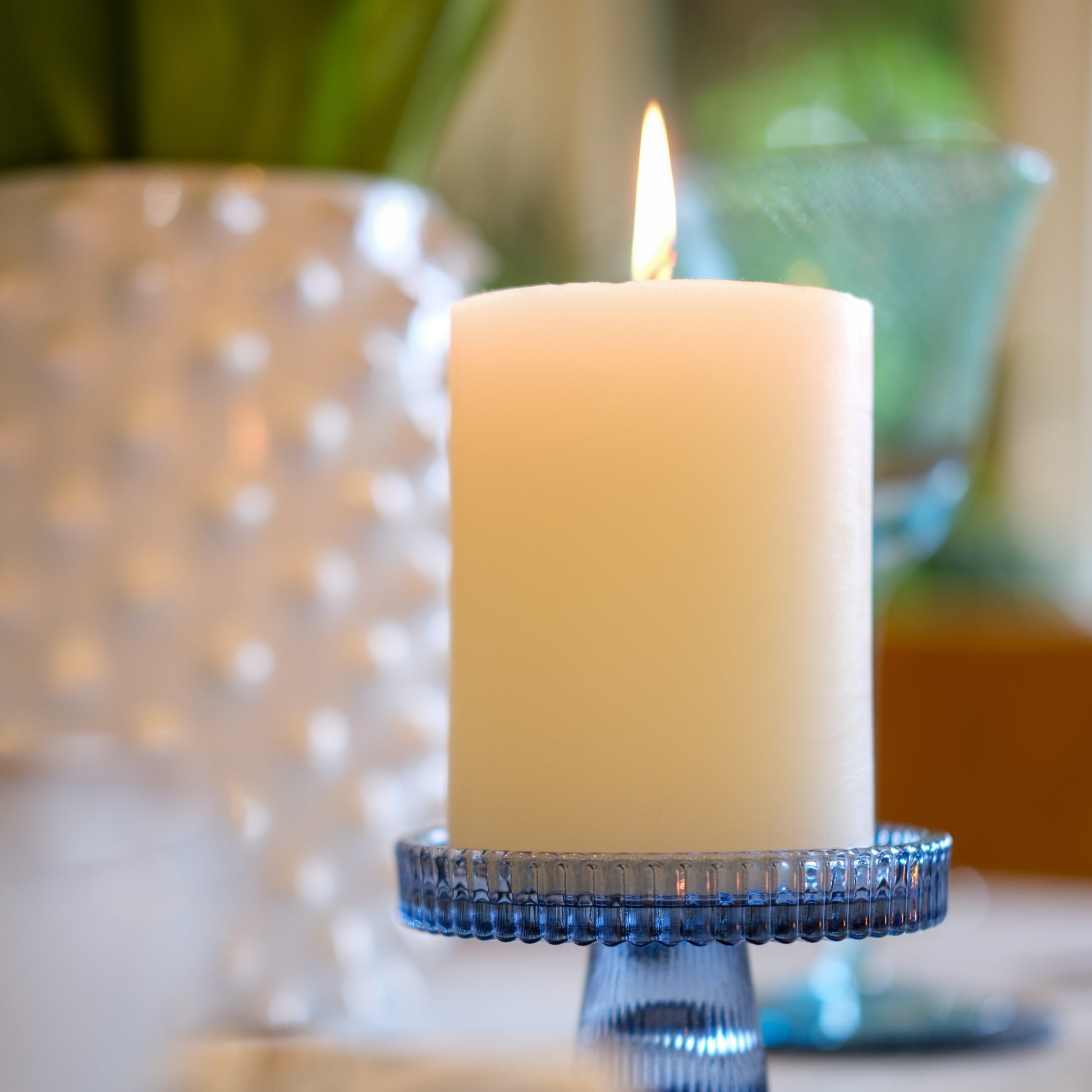 Candle in a blue holder with blurred background