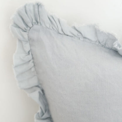 Light blue pillow with ruffled edge on a white background