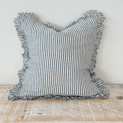 Striped pillow with ruffled edges on a wooden surface